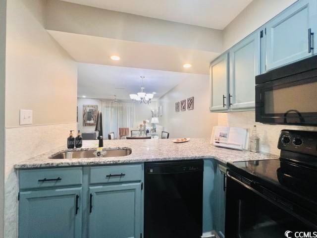 kitchen featuring blue cabinetry, sink, kitchen peninsula, vaulted ceiling, and black appliances