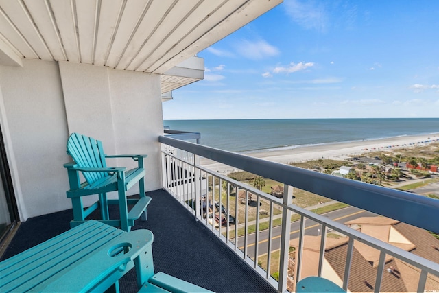 balcony with a water view and a view of the beach