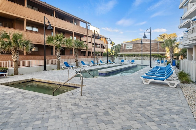 view of pool featuring a community hot tub and a patio area