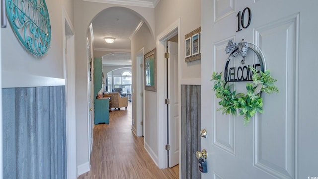 corridor featuring ornamental molding and light hardwood / wood-style floors