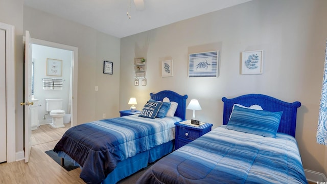 bedroom with ensuite bath, light hardwood / wood-style flooring, and ceiling fan