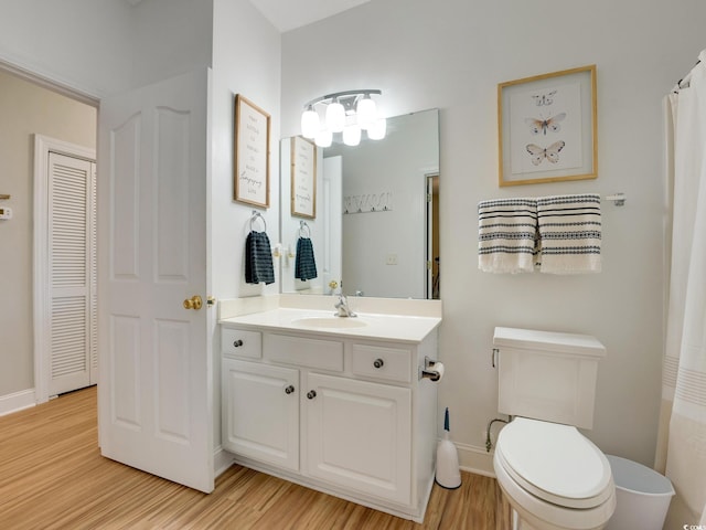 bathroom with vanity, hardwood / wood-style flooring, and toilet