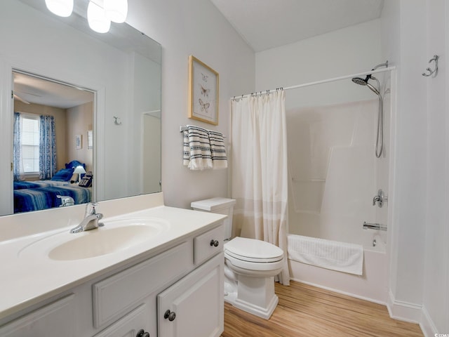 full bathroom with vanity, wood-type flooring, shower / bath combination with curtain, and toilet