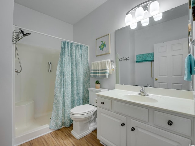 bathroom featuring hardwood / wood-style floors, oversized vanity, a shower with curtain, and toilet