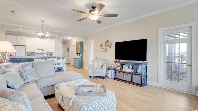 living room featuring ceiling fan with notable chandelier, light hardwood / wood-style flooring, and crown molding