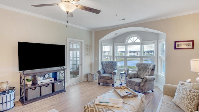 living room with ornamental molding, light hardwood / wood-style flooring, and ceiling fan