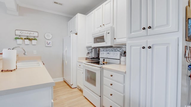 kitchen featuring sink, white appliances, tasteful backsplash, white cabinetry, and light hardwood / wood-style flooring