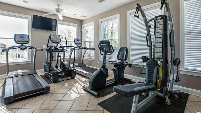 workout area with ceiling fan and light tile floors