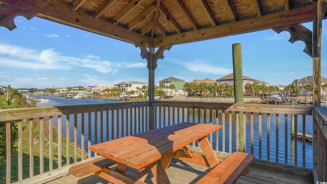 wooden terrace featuring a water view and a gazebo