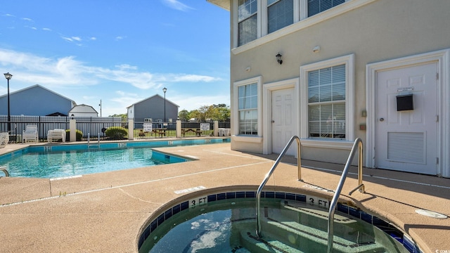 view of swimming pool with a patio area and a community hot tub