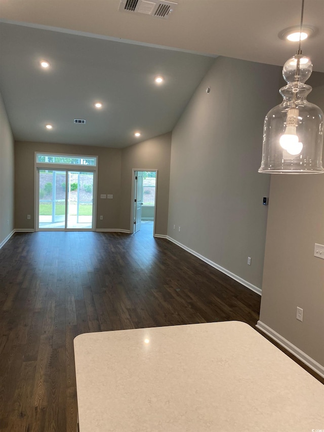 unfurnished living room with dark wood-type flooring and vaulted ceiling