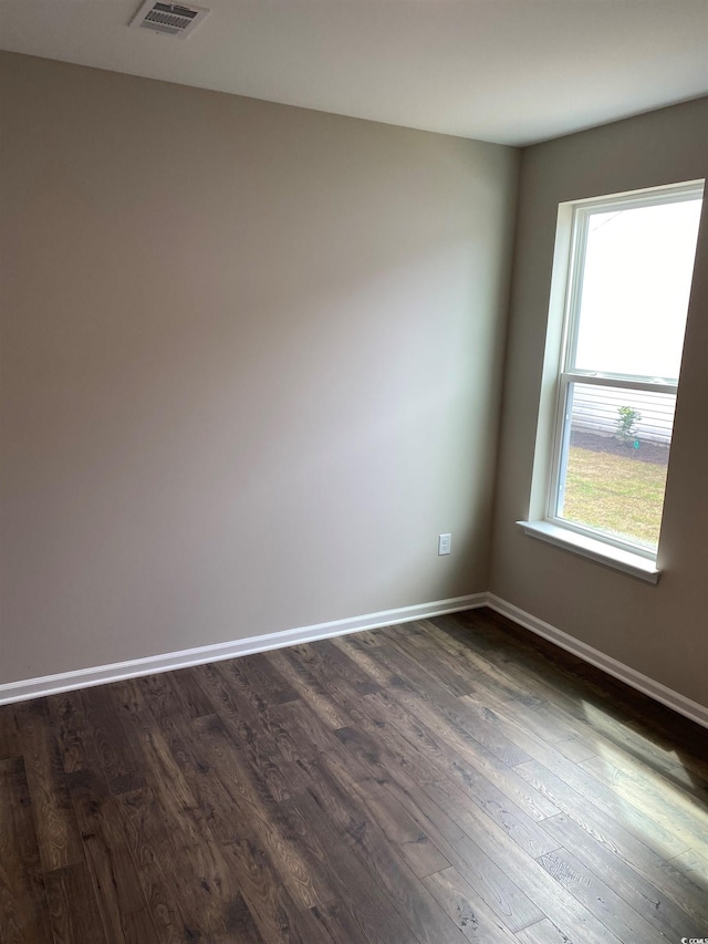 empty room with dark hardwood / wood-style flooring