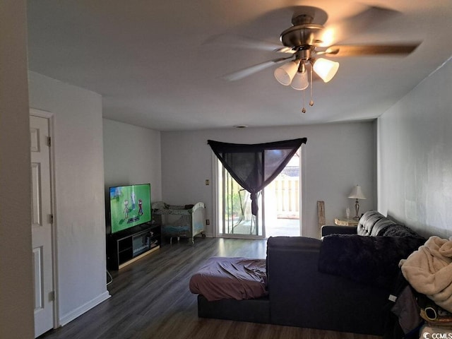 living room featuring ceiling fan and dark wood-type flooring