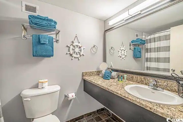 bathroom featuring toilet, tile floors, and large vanity