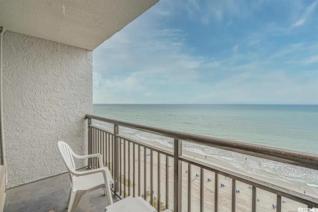 balcony featuring a beach view and a water view