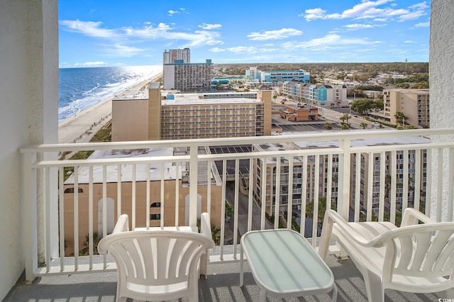 balcony with a water view and a view of the beach