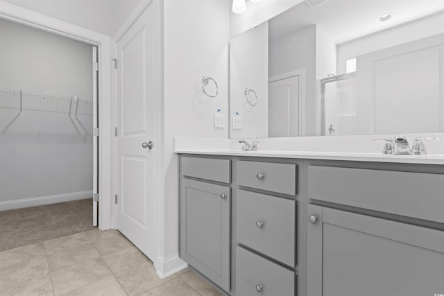 bathroom featuring tile patterned flooring, vanity, and walk in shower