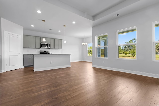 unfurnished living room with dark hardwood / wood-style flooring and an inviting chandelier