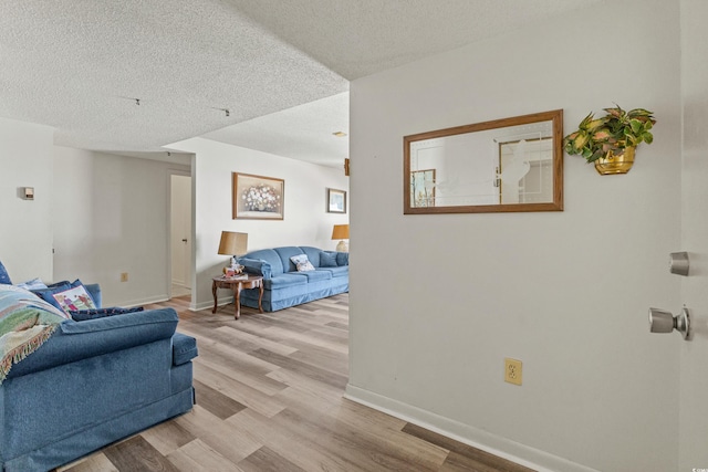 living room featuring light hardwood / wood-style flooring and a textured ceiling