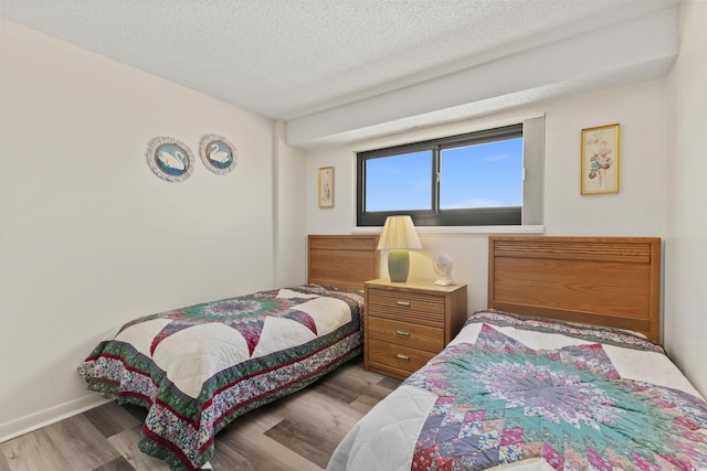 bedroom featuring a textured ceiling and hardwood / wood-style floors