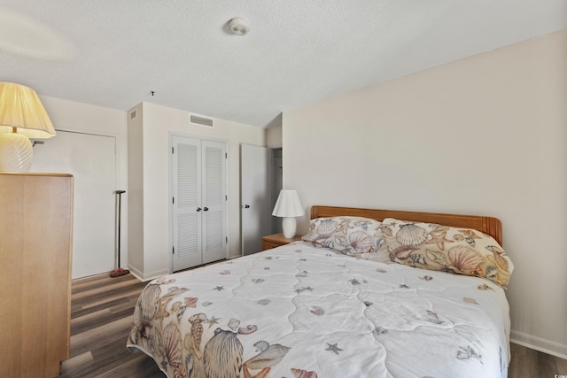 bedroom featuring dark hardwood / wood-style flooring and a textured ceiling