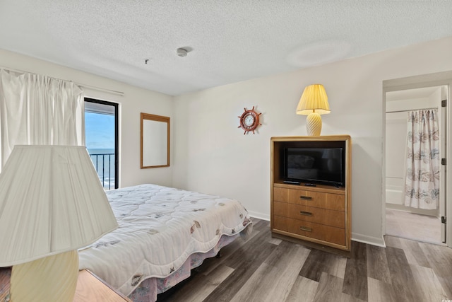 bedroom featuring a textured ceiling, hardwood / wood-style floors, and ensuite bathroom