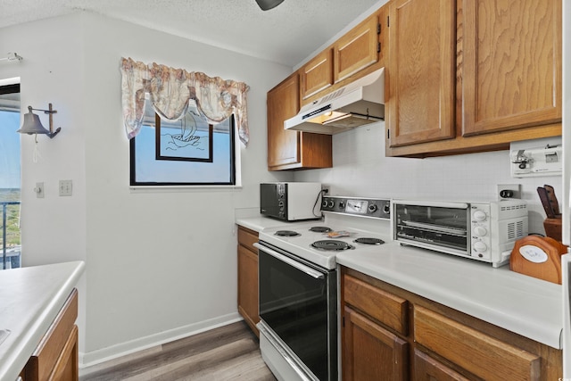 kitchen featuring hardwood / wood-style floors, white range with electric cooktop, and a textured ceiling