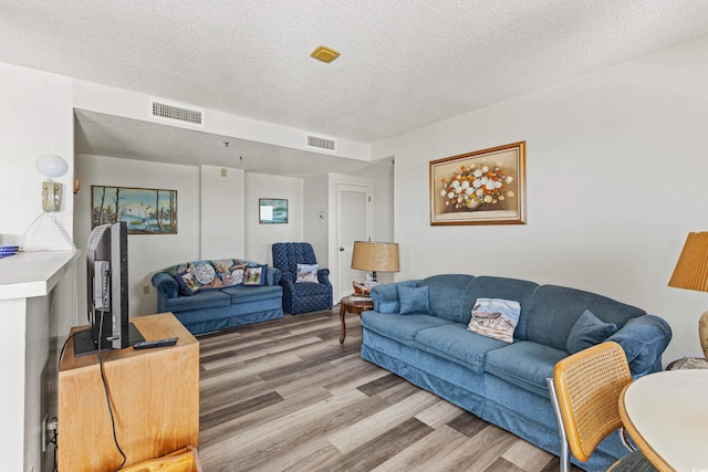 living room featuring a textured ceiling and hardwood / wood-style floors