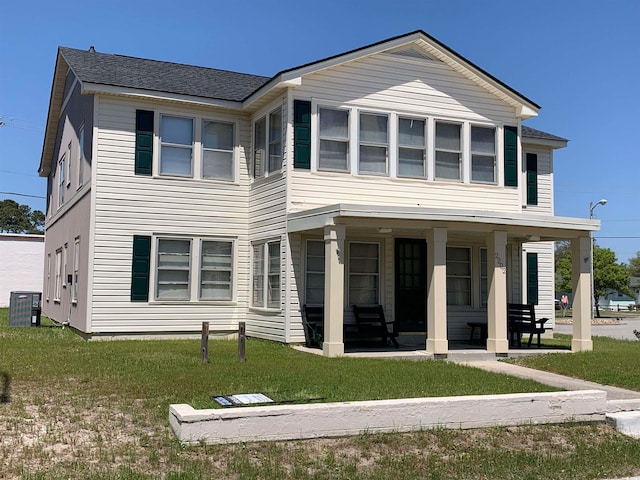 view of front of property with a front lawn, central air condition unit, and covered porch