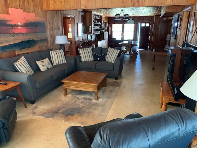 living room with wood walls and light tile flooring