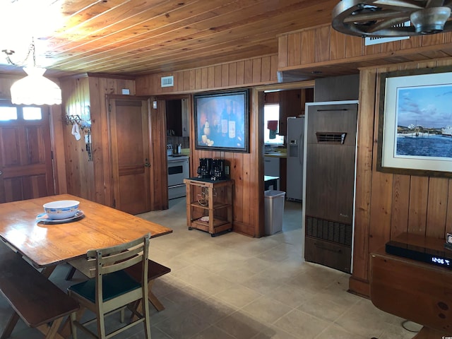 dining room featuring wooden walls, wooden ceiling, and light tile floors