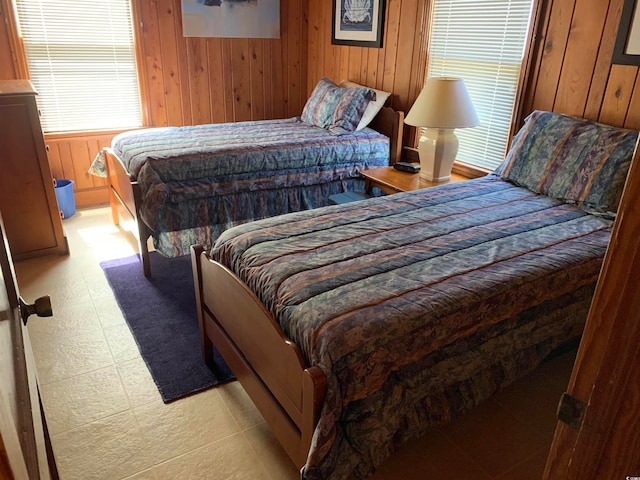 bedroom featuring wood walls and light tile flooring