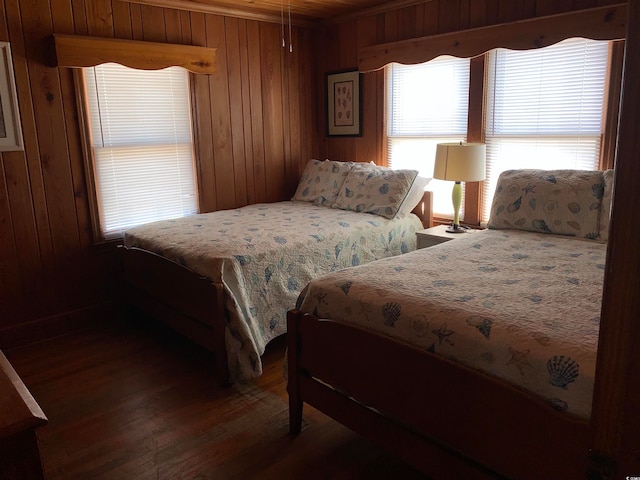 bedroom with dark hardwood / wood-style floors and wood walls