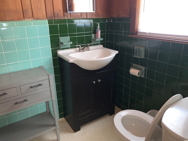 bathroom with backsplash, toilet, vanity, and tile walls