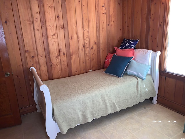 bedroom featuring light tile floors and wooden walls