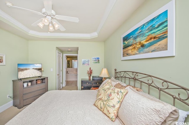 carpeted bedroom with crown molding, ceiling fan, a raised ceiling, and ensuite bathroom