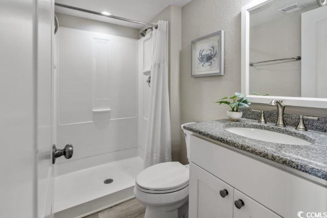 bathroom with curtained shower, oversized vanity, hardwood / wood-style flooring, and toilet