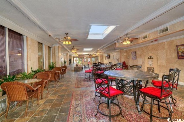 dining area with ceiling fan, crown molding, and dark tile flooring