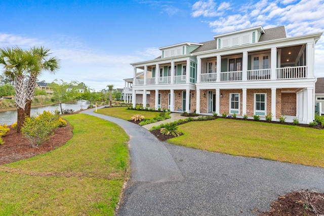 view of front of property featuring a balcony and a front yard