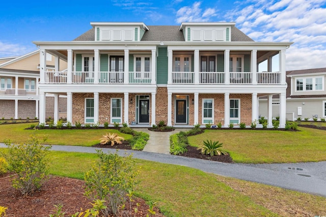 view of front of home with a front lawn and a balcony