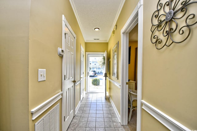 hallway featuring a textured ceiling, light tile floors, and ornamental molding