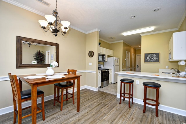 dining room featuring a textured ceiling, an inviting chandelier, light tile floors, and ornamental molding