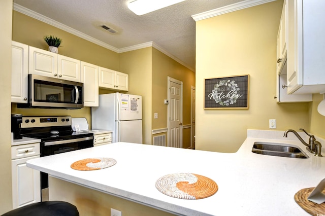 kitchen featuring appliances with stainless steel finishes, a textured ceiling, a breakfast bar, sink, and crown molding