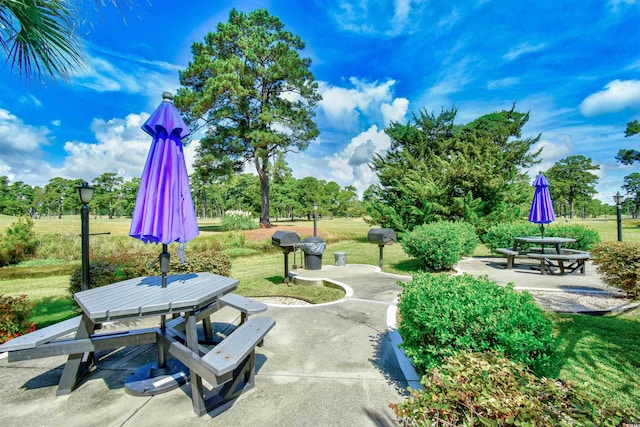 view of property's community featuring a patio area and a lawn