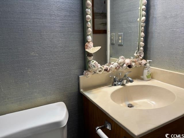 bathroom with vanity with extensive cabinet space and toilet