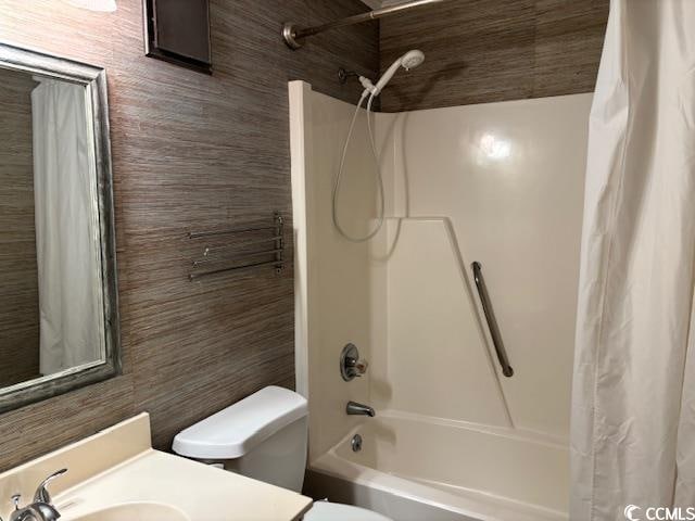 full bathroom with sink, tile walls, toilet, and shower / bathtub combination with curtain