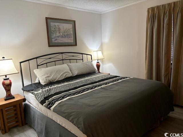 212 2nd Ave N Unit 362, North Myrtle Beach, SC 29582 - bedroom with a textured ceiling, ornamental molding, and wood finished floors