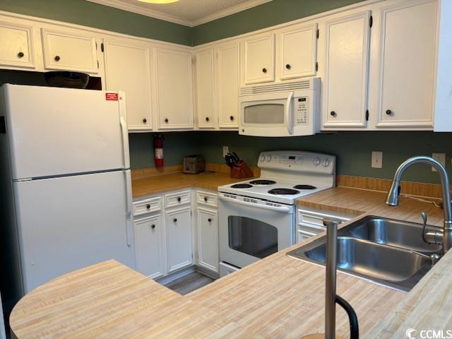 kitchen with white appliances, crown molding, sink, and white cabinetry