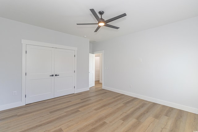 unfurnished bedroom with a closet, light wood-type flooring, a ceiling fan, and baseboards