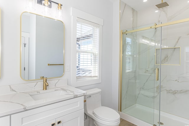 bathroom featuring vanity, a marble finish shower, and toilet